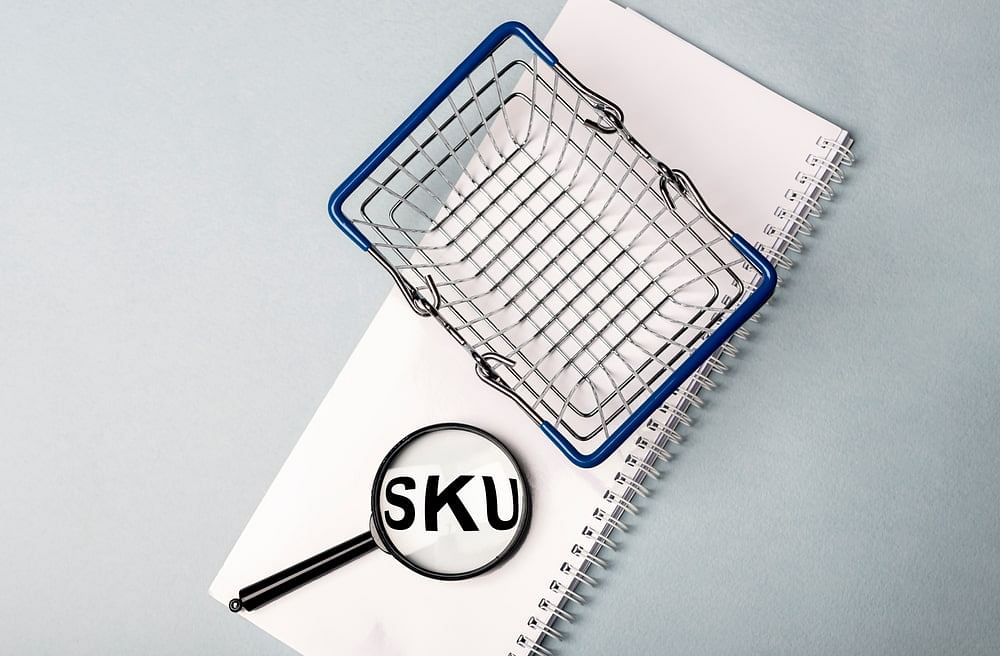 SKU through magnifier on white notebook with shopping basket