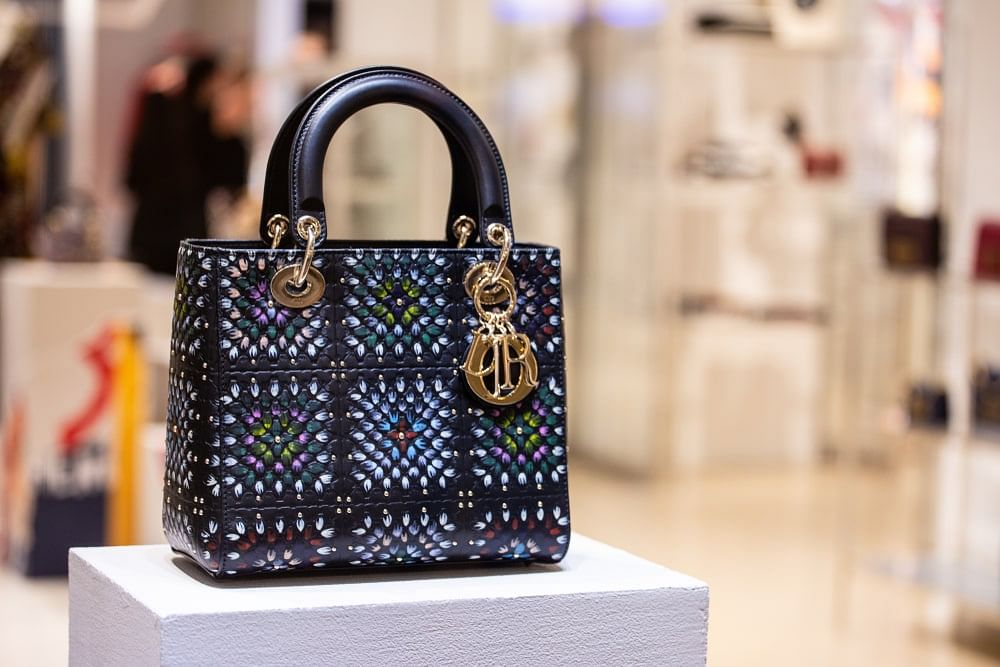 Dior handbag on display in a store. Dior is a participating Amazon luxury brand