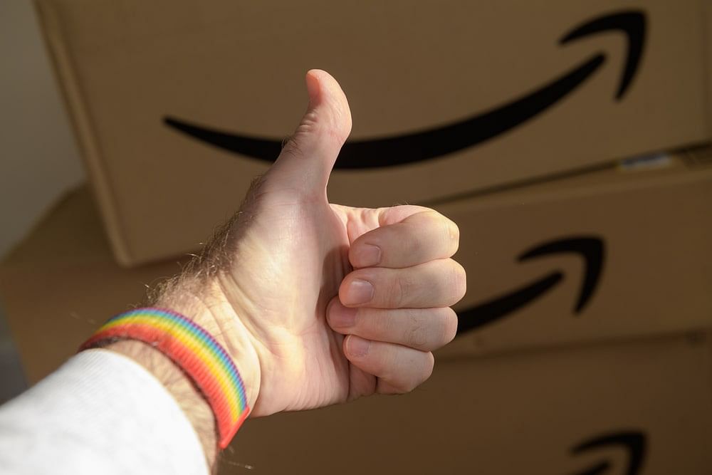 Male hand with a thumb up, showing approval of the stack of Amazon parcels in his room