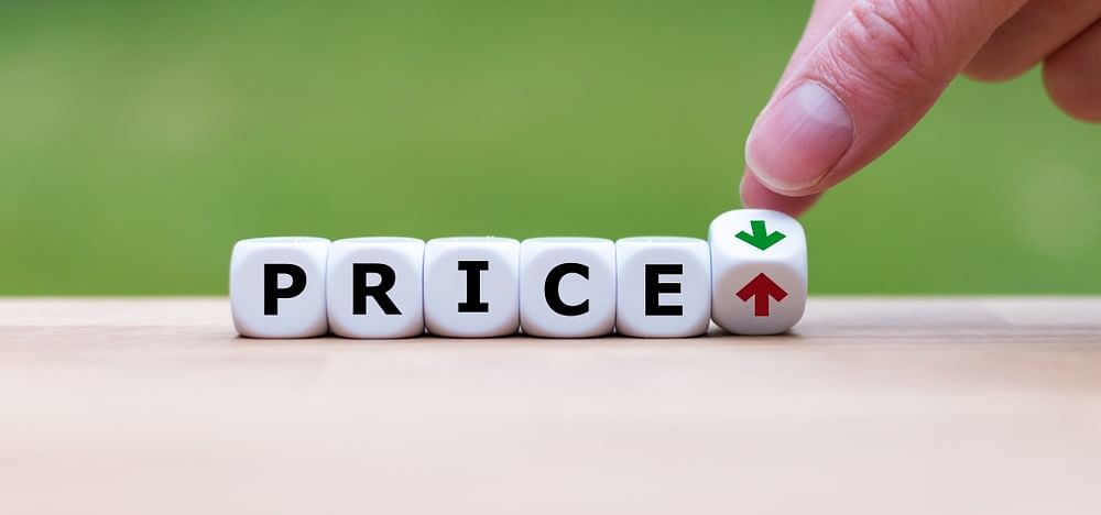 the text “price” spelled out using dice and a man adjusting a die with red upward arrow and green downward arrow
