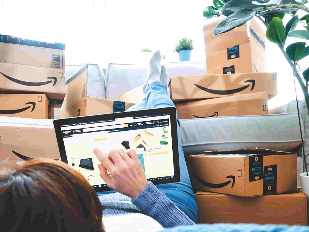 Person browsing Amazon with parcels stacked on top of each other