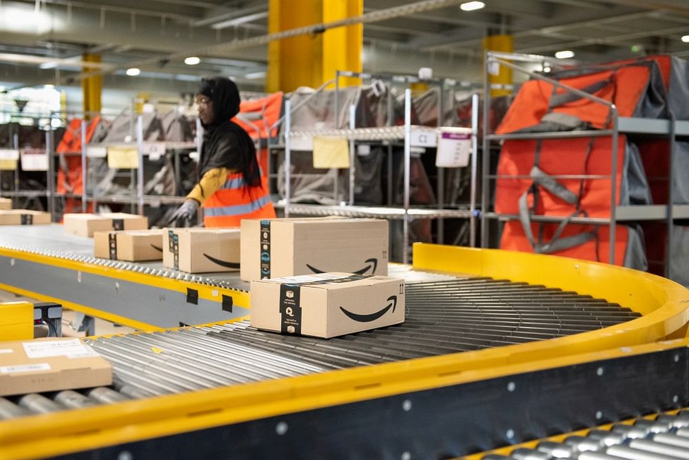 Amazon logistics, a worker sorting packages on a conveyor