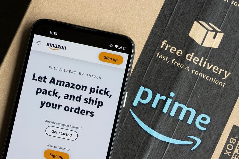 A smartphone showing the web page of Fulfillment by Amazon placed on top of an Amazon Prime branded delivery box