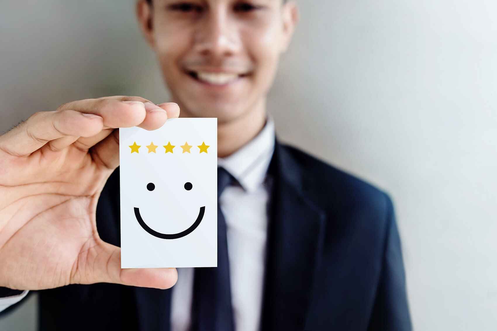 does fba really work - businessman smiling and holding a five-star review card