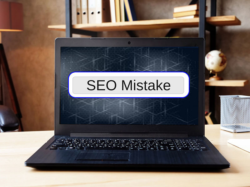 seo mistake text on a laptop placed on a wooden table