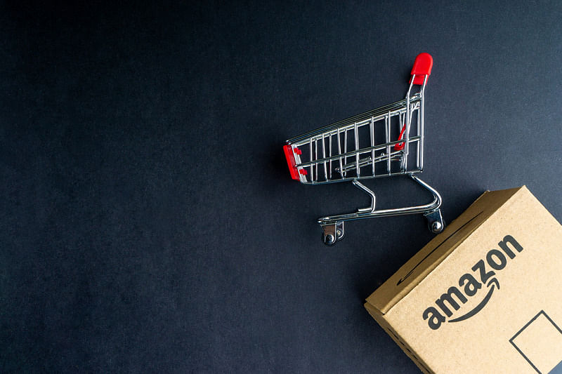 amazon conversion rate - an amazon box and a shopping cart on black background