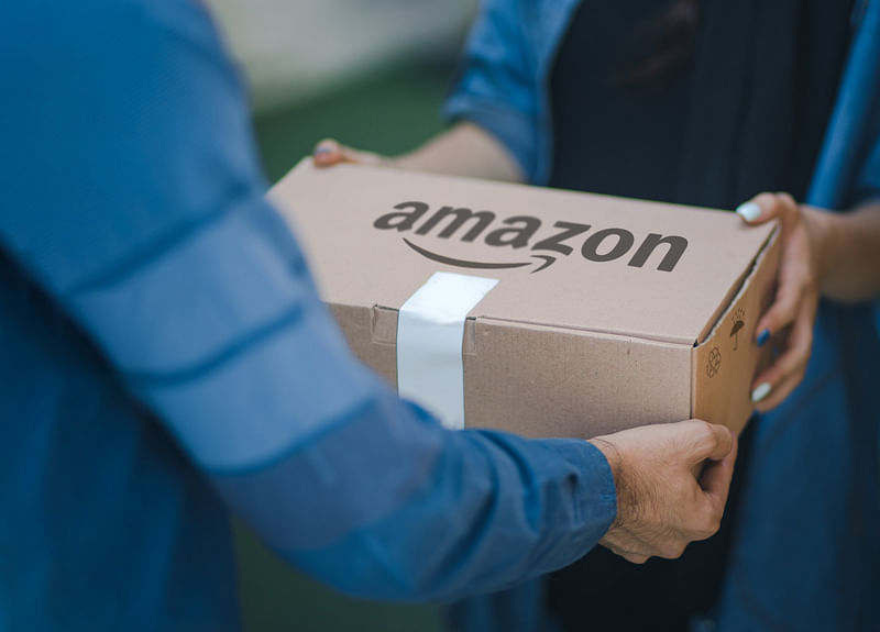 2 people holding an amazon package