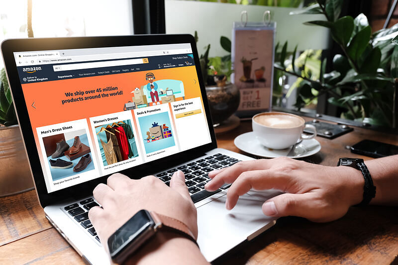 hands typing on a laptop showing Amazon’s homepage illustrating amazon online shopping
