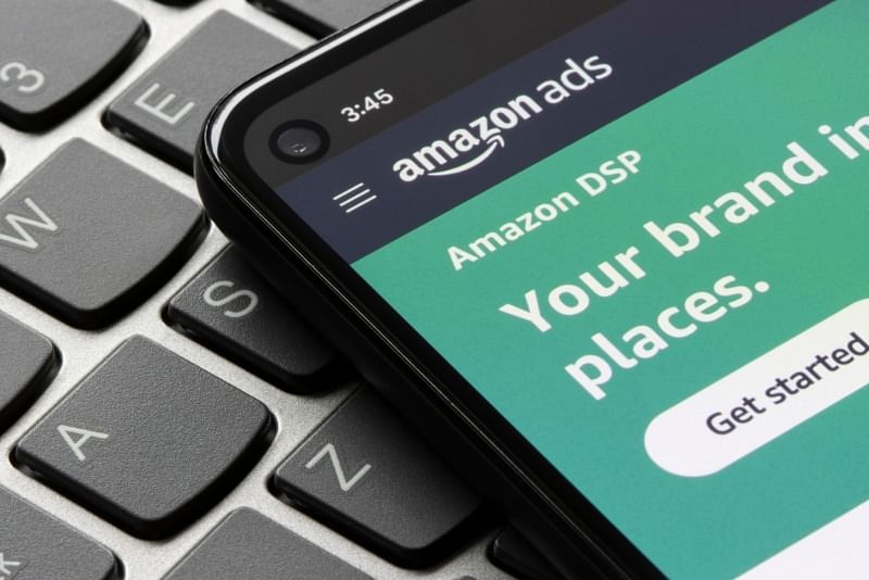 sponsored brands - shot of a phone on top of a laptop keyboard, showing amazon ads and amazon dsp onscreen