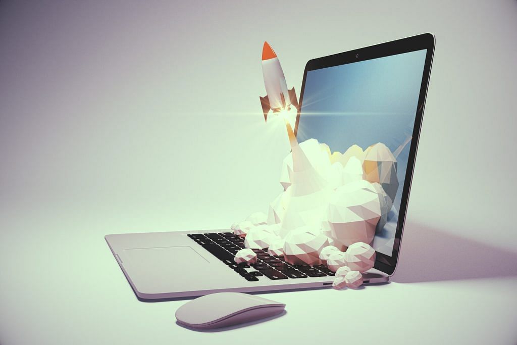A miniature rocket launching up and away from a laptop; smoke from the rocket’s tail blows on the screen and the keyboard