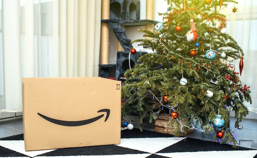 merry christmas - shot of an amazon box next to a christmas tree