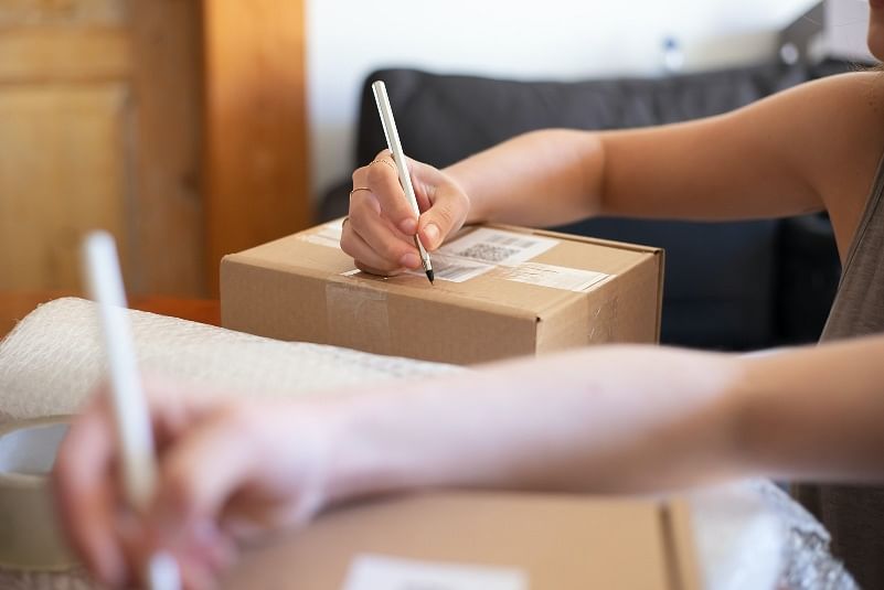 closeup shot of two people writing on their packages
